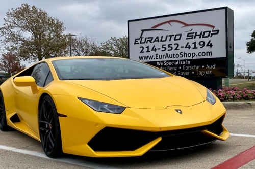 EurAuto Shop in Plano Tx, exotic auto repair and service on a yellow lamborghini that came in for service is parked outside of shop next to EurAuto Shop sign with logo address and phone number