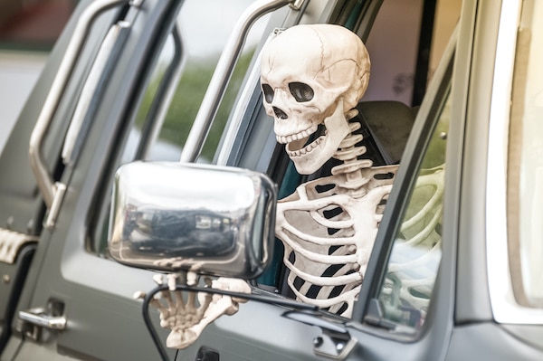 Skeleton waving outside of the window as he is on his way to EurAutoShop for Vehicle Maintenance