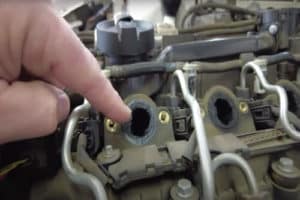 BMW 335d Maintenance Most People Don’t Know About image of EurAuto Shop in Plano Tx owner Michael Gallini's left finger pointing to carbon buildup in the intake system on a BMW 335 d that came in for coolant leak issue