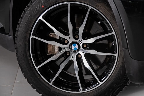 Want Super Fast Tire Changes? Switch to Lug Studs with EurAuto Shop in Plano, TX and BMW aftermarket installs; close up image of BMW tire and rim