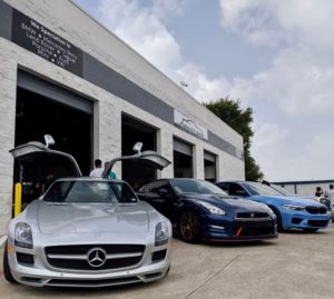 Need European or Exotic Vehicle Auto Repair in Plano TX? You Must Read This! with EurAuto Shop in Plano TX; image of exotic and european vehicles parked outside of open bay doors of shop, silver mercedes with scissor doors open