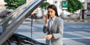 The Good, Bad, and Ugly Quotes for Auto Repair in Plano TX  Auto Repair Estimates; image of young business woman explaining repairs on phone while pointing to her car engine with hood of car up