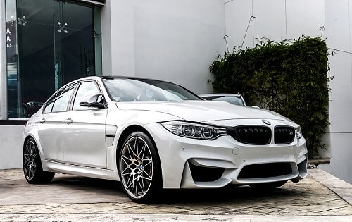 Laying Pipe in the BMW F80 M3 | EurAuto Shop in Plano, TX. Image of a white BMW M3 (F80) in the city street.