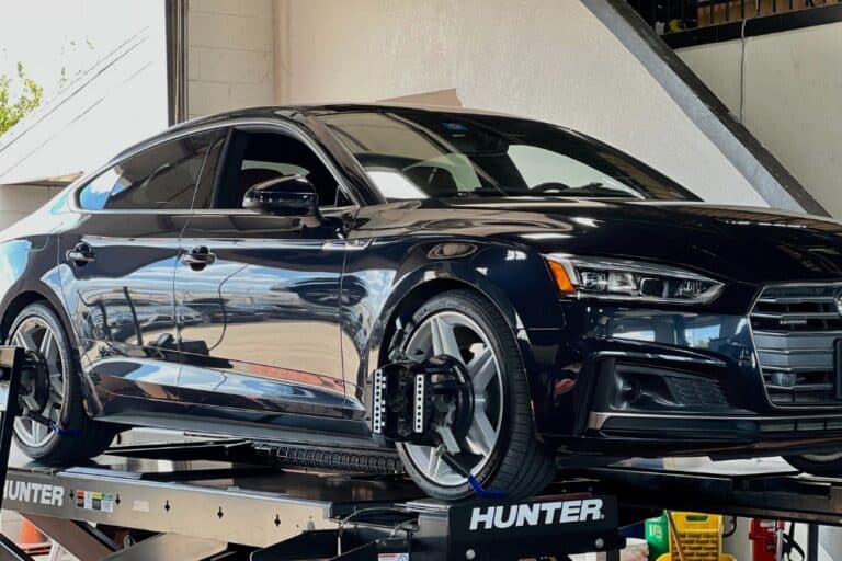 Wheel Alignment, Auto Repair In Plano, TX At EurAuto Shop. Car on lift in auto repair shop during wheel alignment service