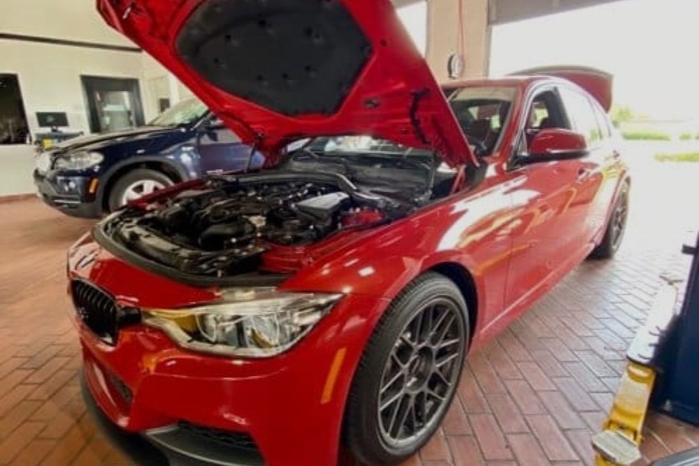 German Auto Repair in Plano TX At EurAuto Shop. Red BMW with open hood in auto repair.
