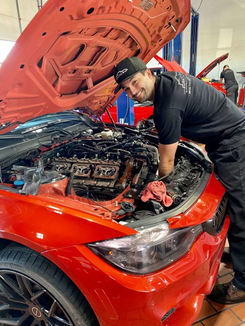 A EurAuto technician working under the hood of a car. Careers at EurAuto are available with great benefits.